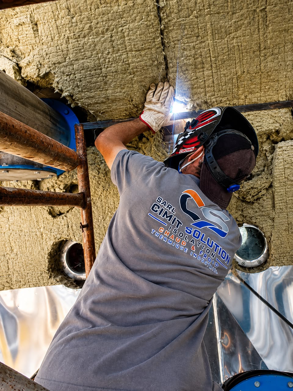 Technicien qualifié réalisant l'isolation thermique d'un équipement industriel